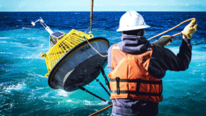 Image of a NOAA buoy being deployed in the ocean